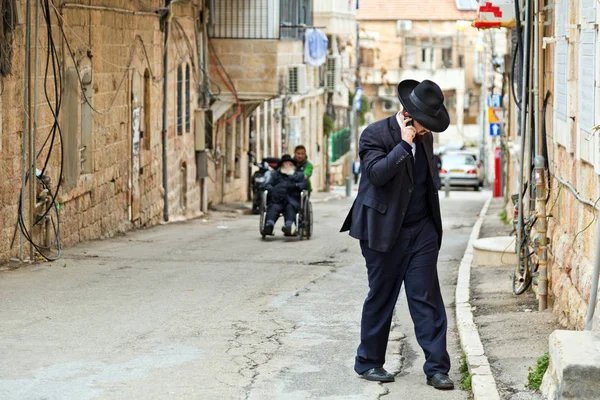 携帯電話で正統派ユダヤ人の男は Jerusale の通りで歩く — ストック写真