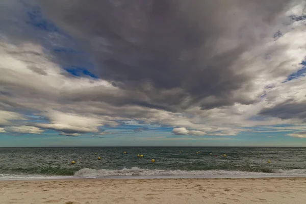 Praia com ondas e nuvens dramáticas — Fotografia de Stock