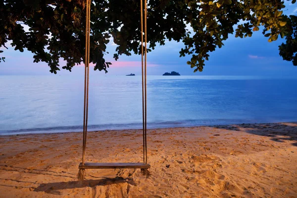 Gunga på solnedgången på stranden — Stockfoto