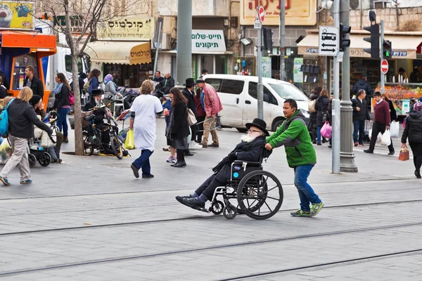 Giovane aiuta a muoversi su una sedia a rotelle — Foto Stock