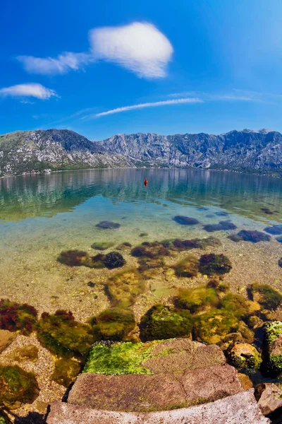 Spiaggia di pietra con mare e montagna — Foto Stock