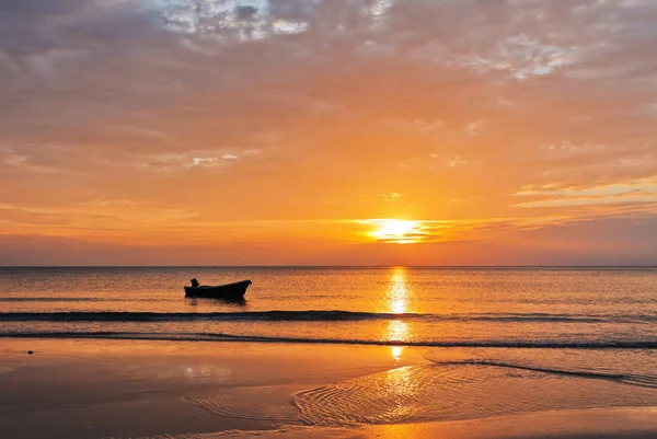 Човен на пляжі на заході сонця — стокове фото