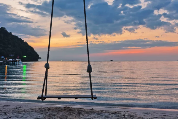 Swing op zonsondergang op het strand — Stockfoto