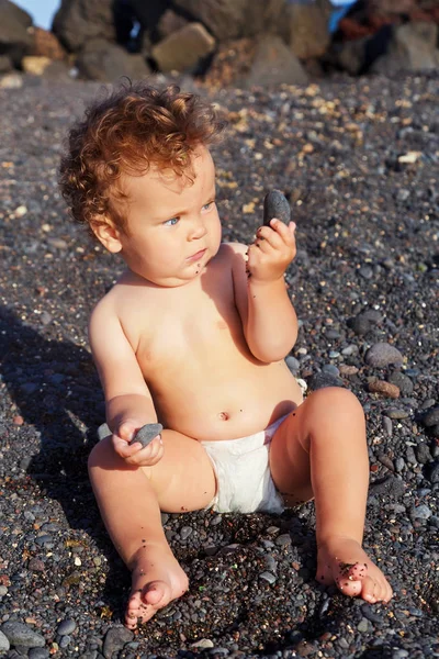 小女孩海滩玩鹅卵石 — 图库照片