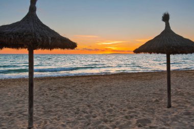 Günbatımı zamanı plaj şemsiyeleri