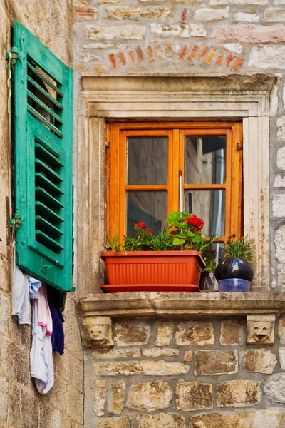 Vecchia finestra in vecchio muro di pietra con fiori — Foto Stock