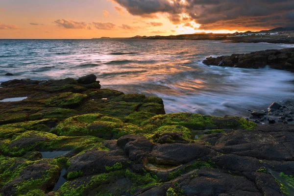 Ηλιοβασίλεμα στη θάλασσα στην παραλία πέτρες — Φωτογραφία Αρχείου