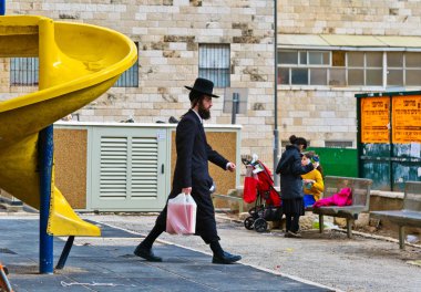 Oyun alanında Jerusalem üzerinde yürüyen Ortodoks Yahudi adam. 