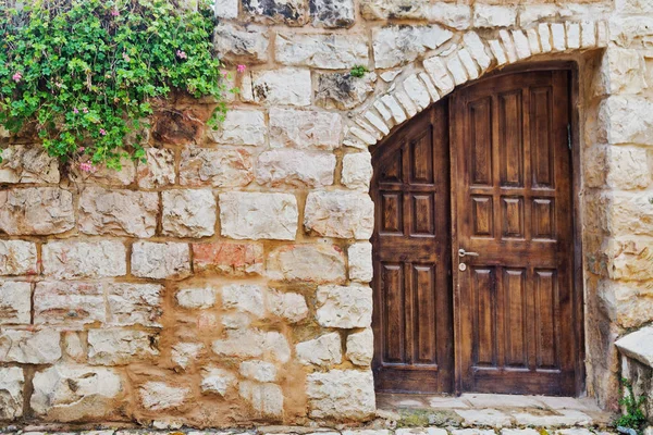 Старая деревянная дверь в каменной стене — стоковое фото