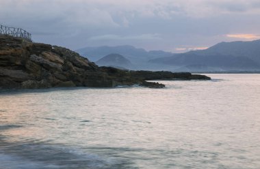 Gün batımında kayalık plajın güzel manzarası.
