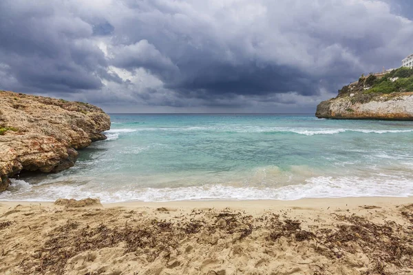Kasvetli bir dramatik gökyüzü altında kayalık plaj — Stok fotoğraf
