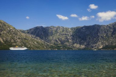 Turist beyazı yolcu gemisi, dağlık arka planda Rocky Bay 'de yelken açıyor. 