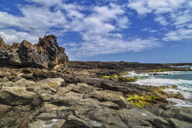 Atlantik Okyanusu kıyısında mavi gökyüzünün altında dalgalar olan vahşi taş plajlar. Tenerife adası. İspanya