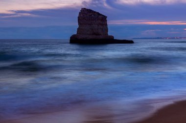 Kayalıkların ve Ferragudo yakınlarındaki sahil manzaralı gün batımı manzarası. Portekiz