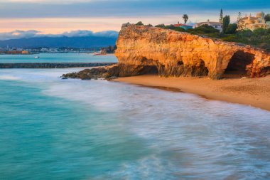 Sahili, kayalıkları ve okyanusu olan güzel bir deniz manzarası. Pintadinho plajı. Ferragudo, Lagoa, Algarve, Portekiz