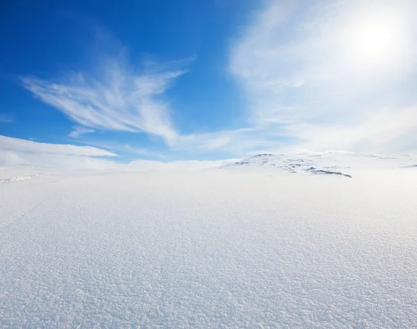 Снежный холм и голубое небо — стоковое фото