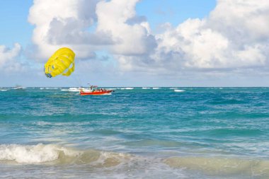 Yazın kumlu bir sahilde el salla.