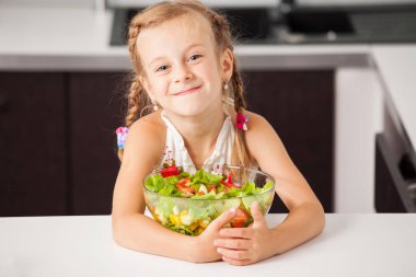 sebze salatası yiyen küçük kız