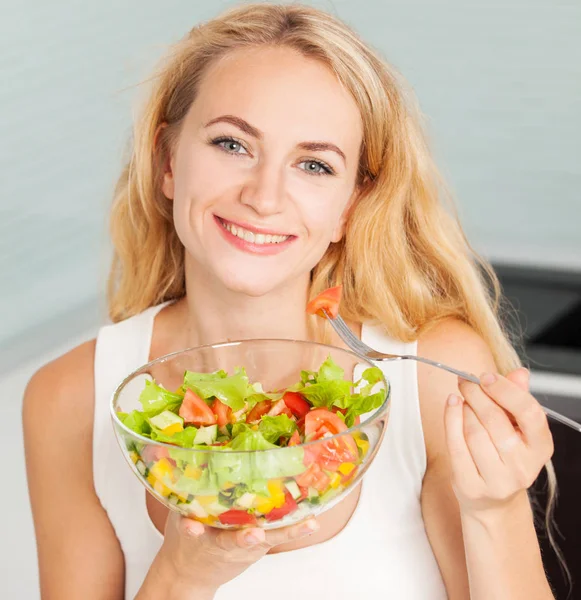 Jovem mulher comendo salada vegetal — Fotografia de Stock