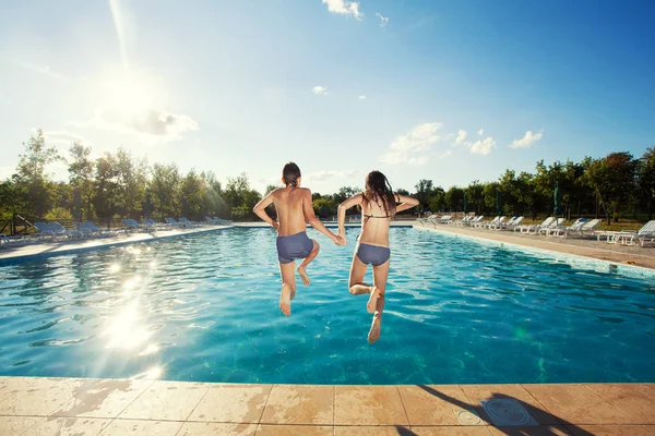 Paar springen in het zwembad — Stockfoto