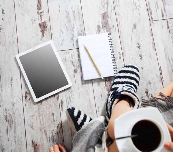 Женщина с чашкой кофе, блокнотом и планшетом — стоковое фото