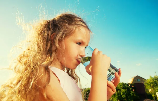 女の子の持株のガラスの水で — ストック写真