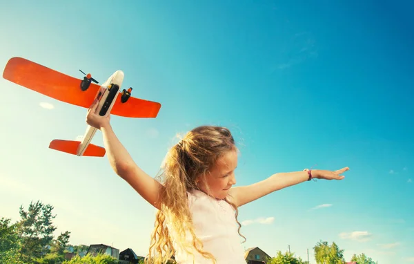 Девушка играет с самолетом — стоковое фото