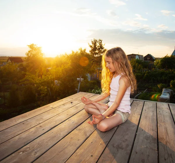 Menina meditando ao pôr do sol — Fotografia de Stock