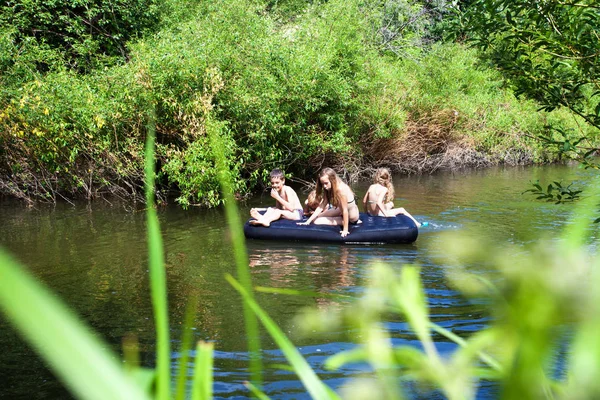 Niños flotando en el río — Foto de Stock