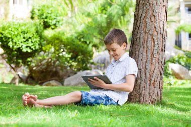 tablet bilgisayar ile çimen çocuk