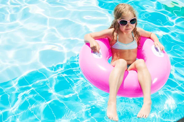 Meisje op opblaasbare ring in zwembad — Stockfoto