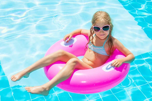 Yüzme havuzunda şişme yüzük takan kız.