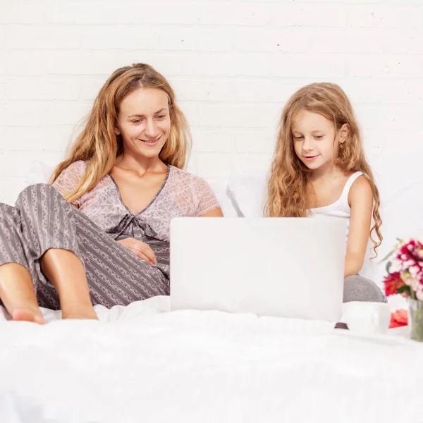 Aile ile laptop yatakta