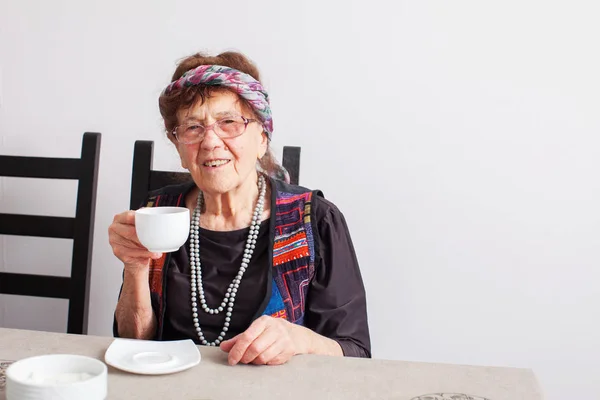 Oude grootmoeder die thee drinkt — Stockfoto