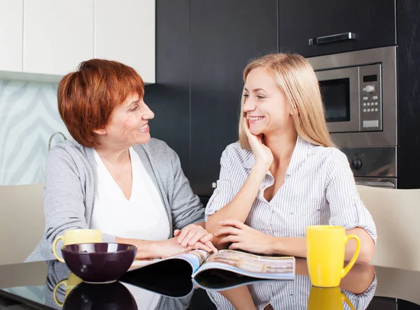 Moeder en dochter lees tijdschrift thuis — Stockfoto