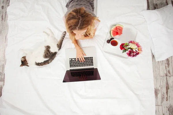 Jovem mulher com laptop na cama — Fotografia de Stock