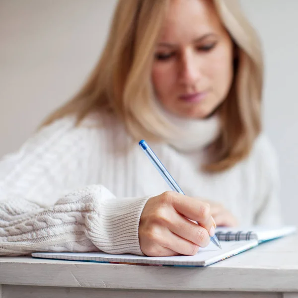 Kvinna skriva penna i anteckningsbok Stockbild