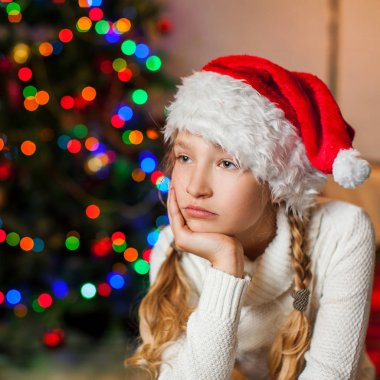 Evdeki Noel ağacının yanında üzgün bir kız