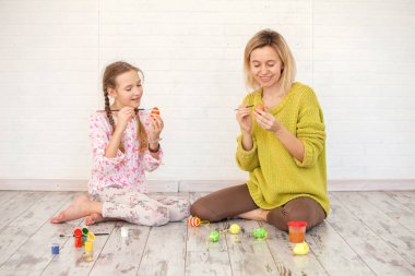 Anne ve çocuk Paskalya yumurtalarını süslüyor.