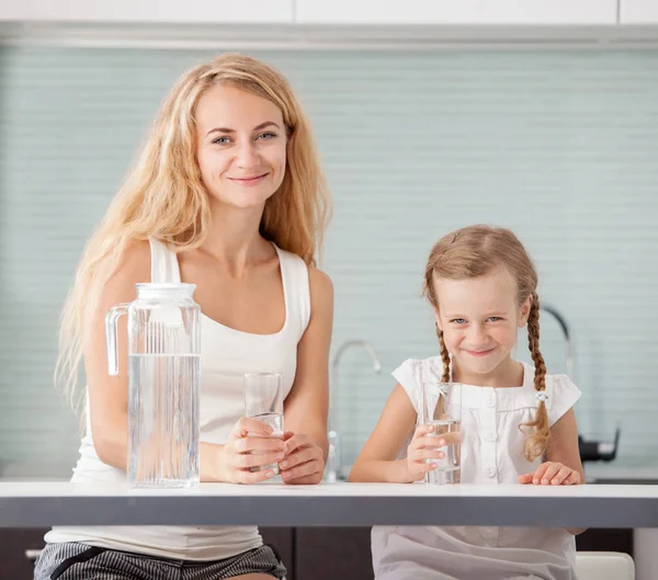 Ребенок с матерью пьет воду — стоковое фото