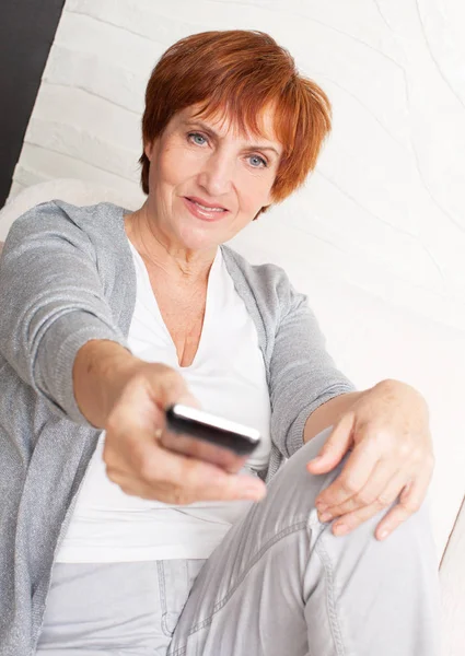 Adult woman with remote control — Stock Photo, Image