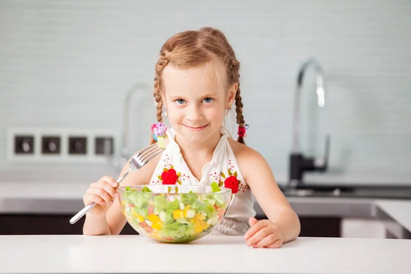 Klein meisje eten plantaardige salade — Stockfoto