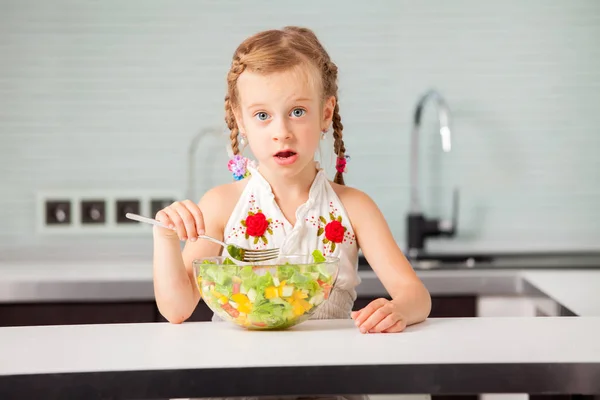 Klein meisje eten plantaardige salade — Stockfoto