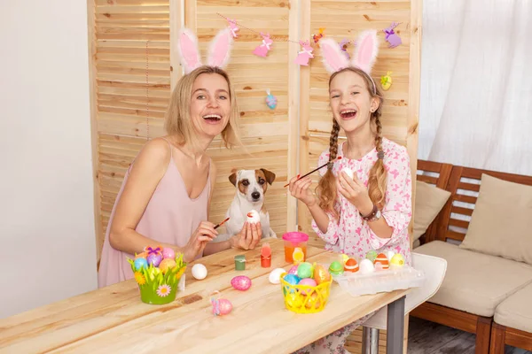 Femme heureuse avec enfant peinture oeufs de Pâques — Photo