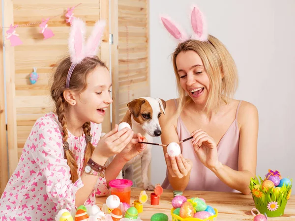 Femme heureuse avec enfant peinture oeufs de Pâques — Photo