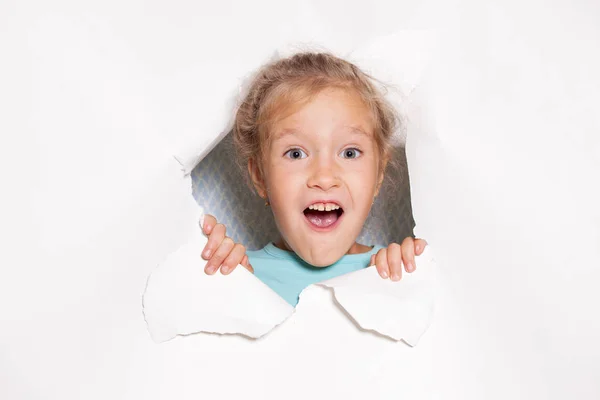 Bambino sorpreso guardando fuori da un buco di carta — Foto Stock