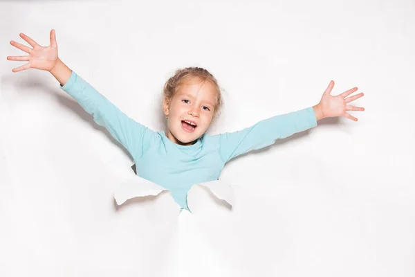 Kind op zoek uit een gat in papier — Stockfoto