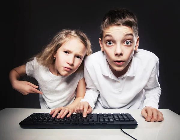 Förvånade barn tittar på en dator Stockfoto