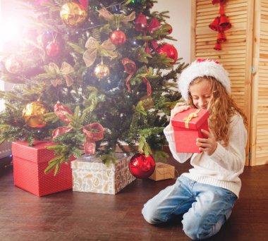 Noel ağacının yanında hediyeli bir çocuk
