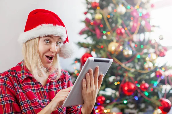 Mujer usando tableta delante del árbol de navidad —  Fotos de Stock